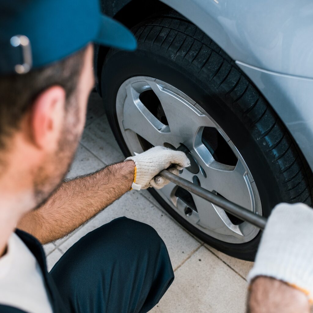 selective focus of car mechanic changing car tire in car service