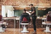 Barber Cutting Hair In A Barbers Shop.