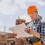 Builder looking at plans to know where the next plot has to be built.