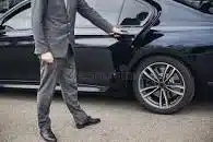 Chauffeur opening a car door for the client.