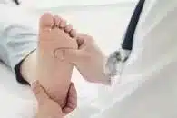 A chiropodist & podiatrist checking a patients foot