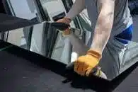 A glazier picking up a pane of glass.