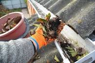 Gutter being cleaned out of rubble.
