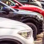 A variety of modern cars, parked with their fronts in towards the curb.