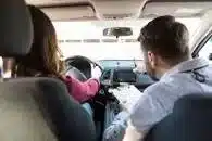A driving school instructor helping a new learner driver