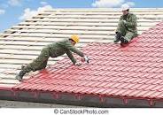 Two roofers on a roof laying tiles on a new roof.