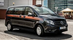 A  black taxi Cab taking a client to their destination.