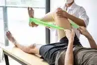 A physiotheraist helping an injured clent get back to fitmess.