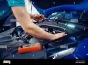 A person checking over electrics on a car.