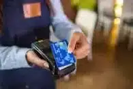 A card reader in a hand of an employee taking payment for gioods on their merchant services