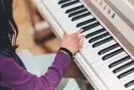 A music teacher teaching a person to play the piano.
