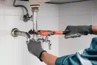 Plumber fixing a leaking sink.