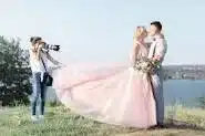 A photographer taking wedding photos of a bride & groom.