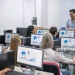 A class of people learning new computer skills on a computer training course.