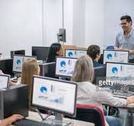 A class of people learning new computer skills on a computer training course.