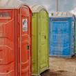 Portable toilets being dropped off at an outside concert.
