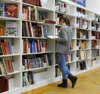 People looking at books on shelves in a bookshop.